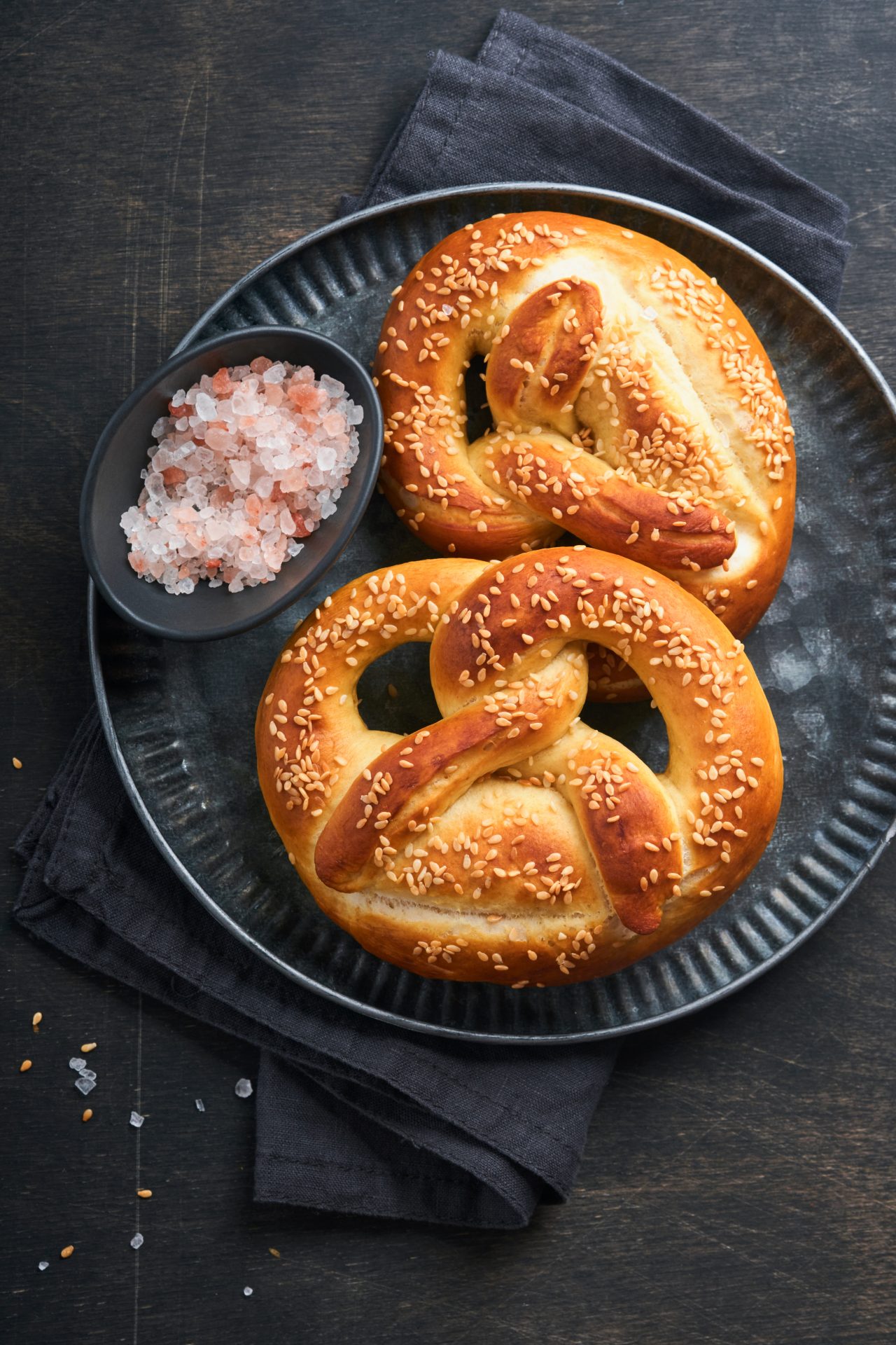 two pretzels on a black plate on a table