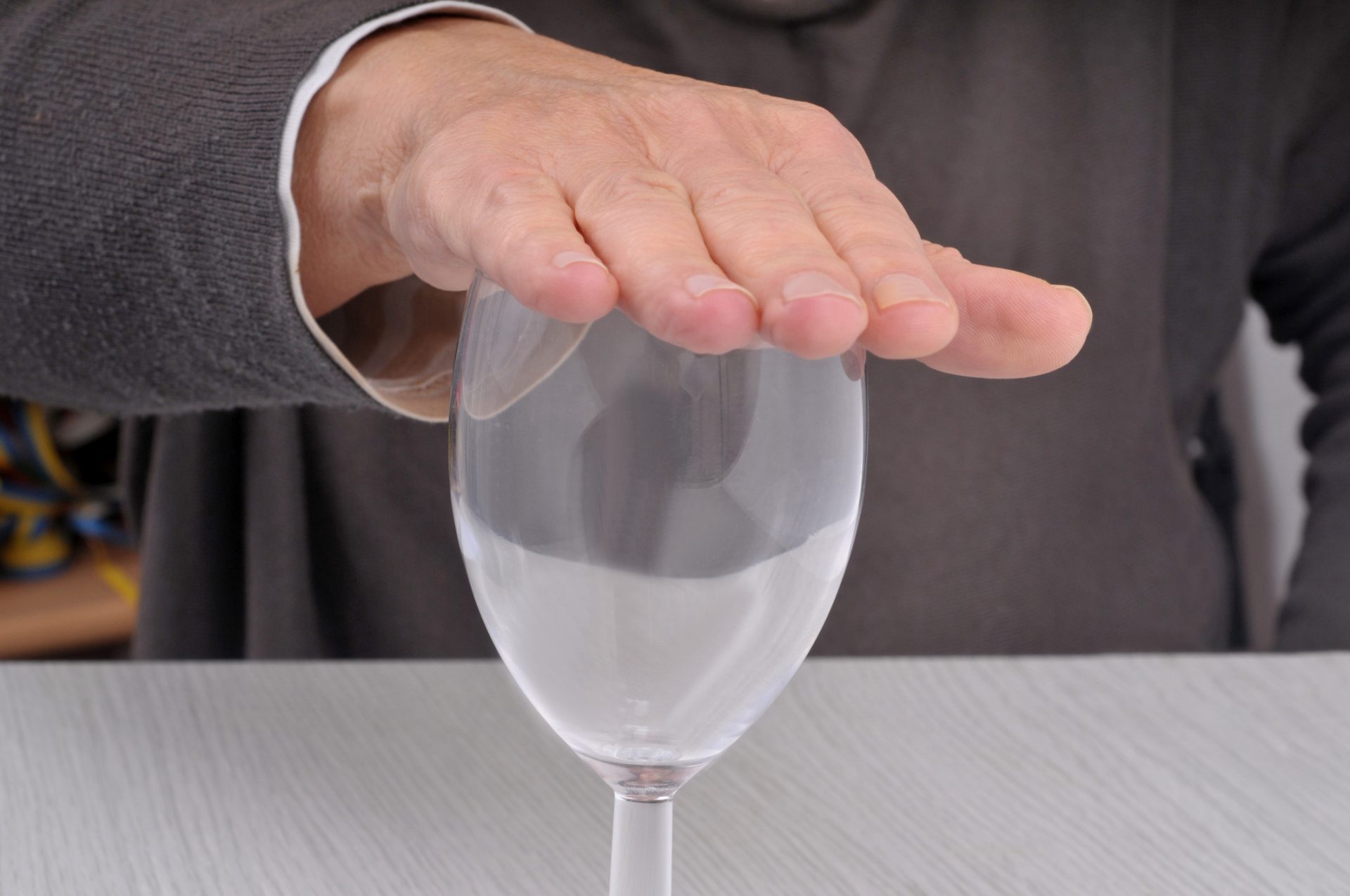 Dry January concept with hand resting on empty glass closeup