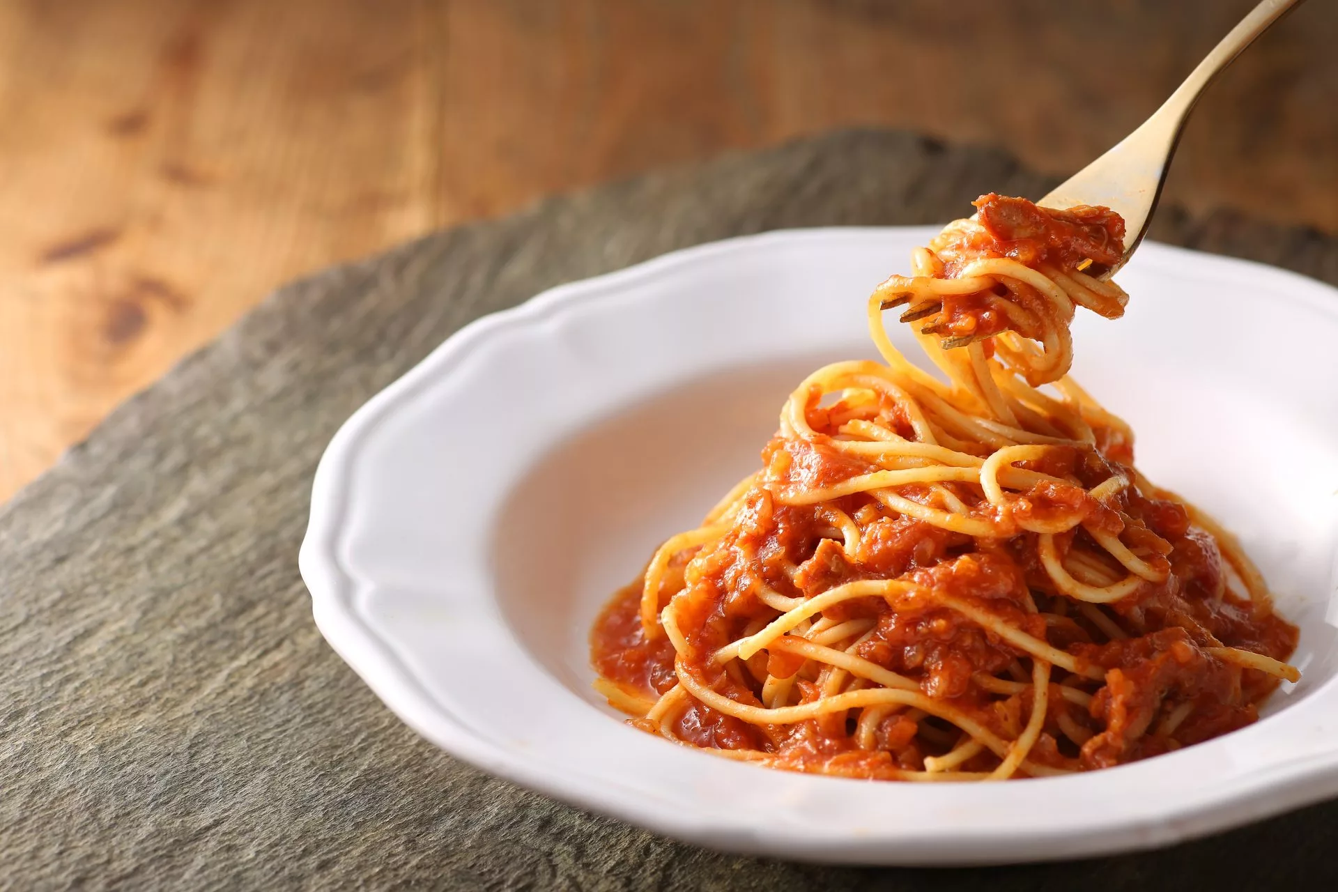 Spaghetti in bowl with a few noodles twisted around fork