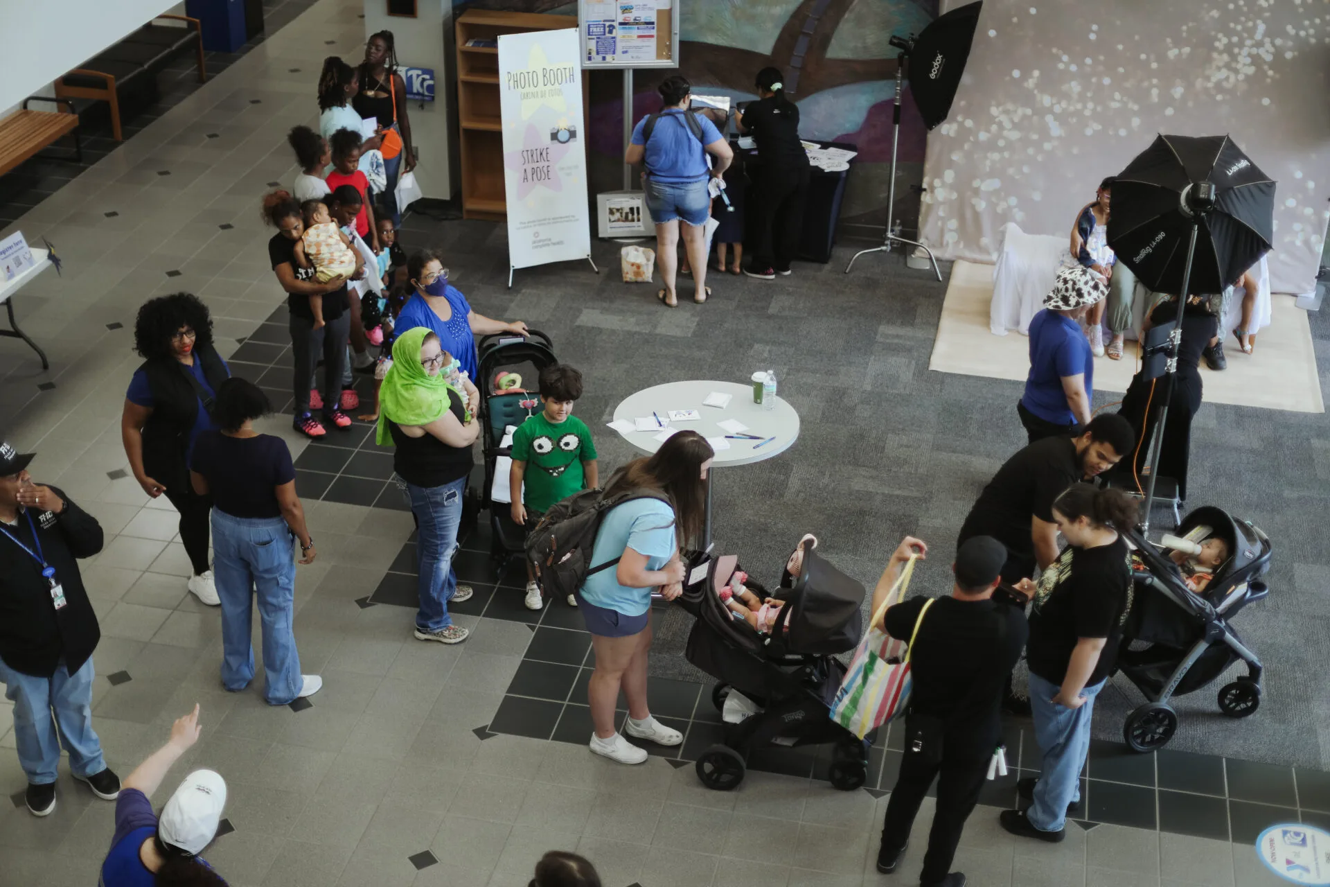 A line of mothers stands and waits for the photo booth at the 2025 North Tulsa Community Baby Shower.