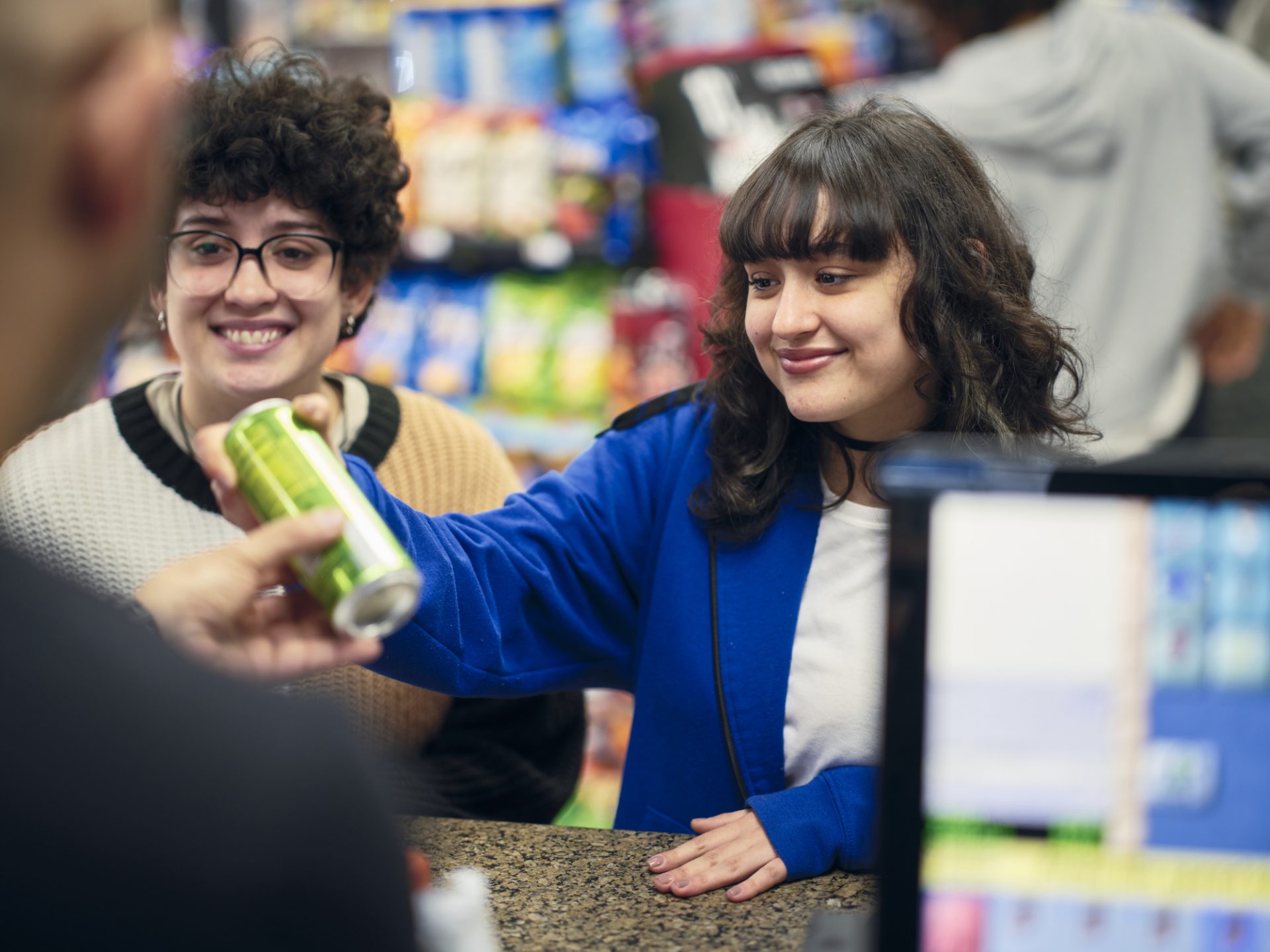 A young couple buying a drink in a small convenience store.