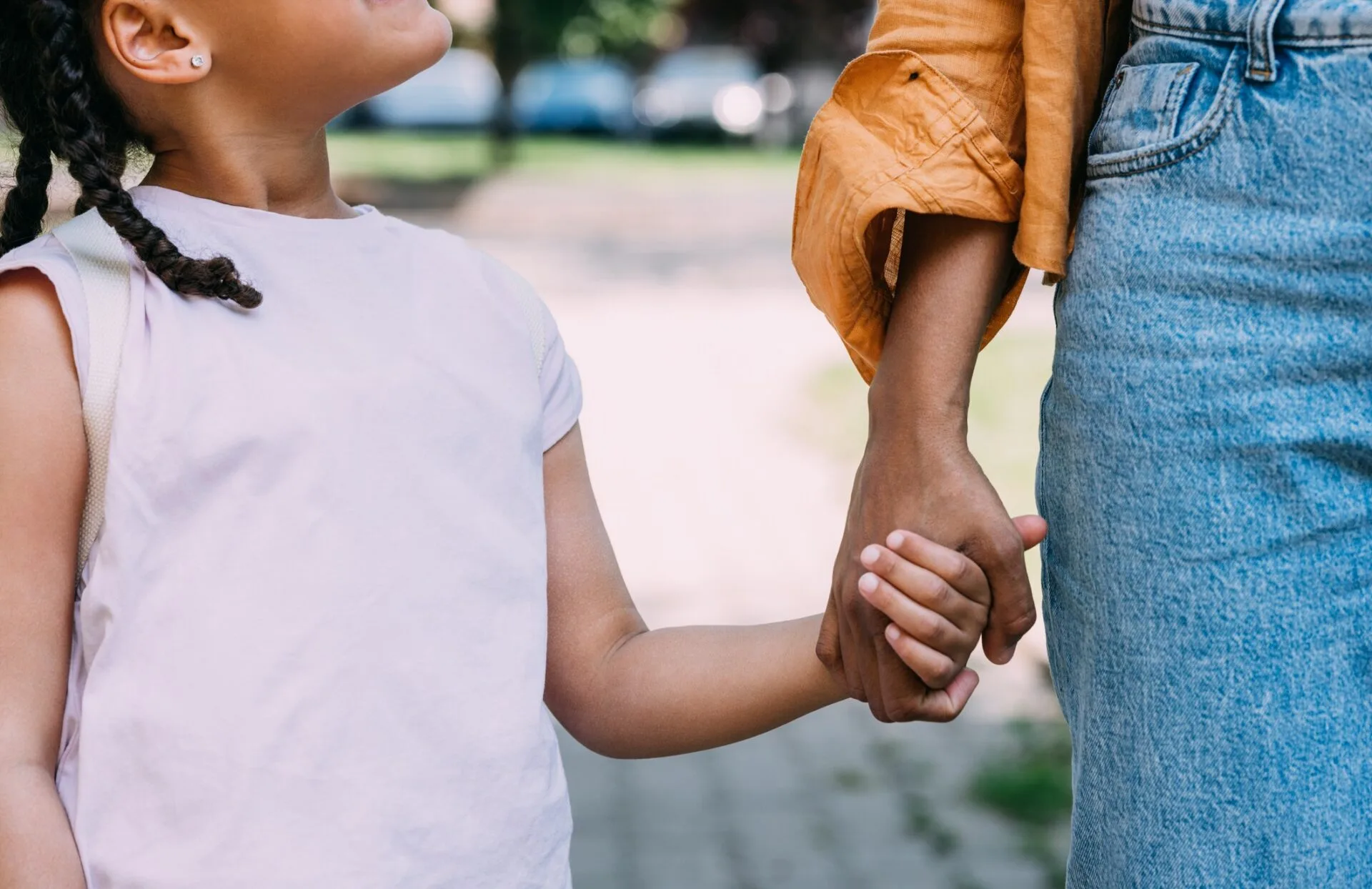 TitleAnonymous Mother and Little Daughter Holding Hands as They Walk down the Street